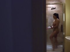 A busty bimbo with silicone knockers is sucking cock in the shower