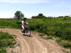 Removing her clothes while riding a bike outside