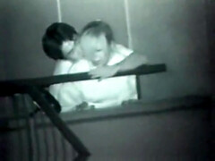 Asian couple making out on stair in public at night