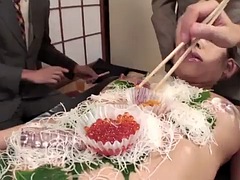 Businessmen eat sushi from the body of a naked girl