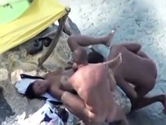 Couple of sluts on the beach caught having a threesome on hidden voyeur cam